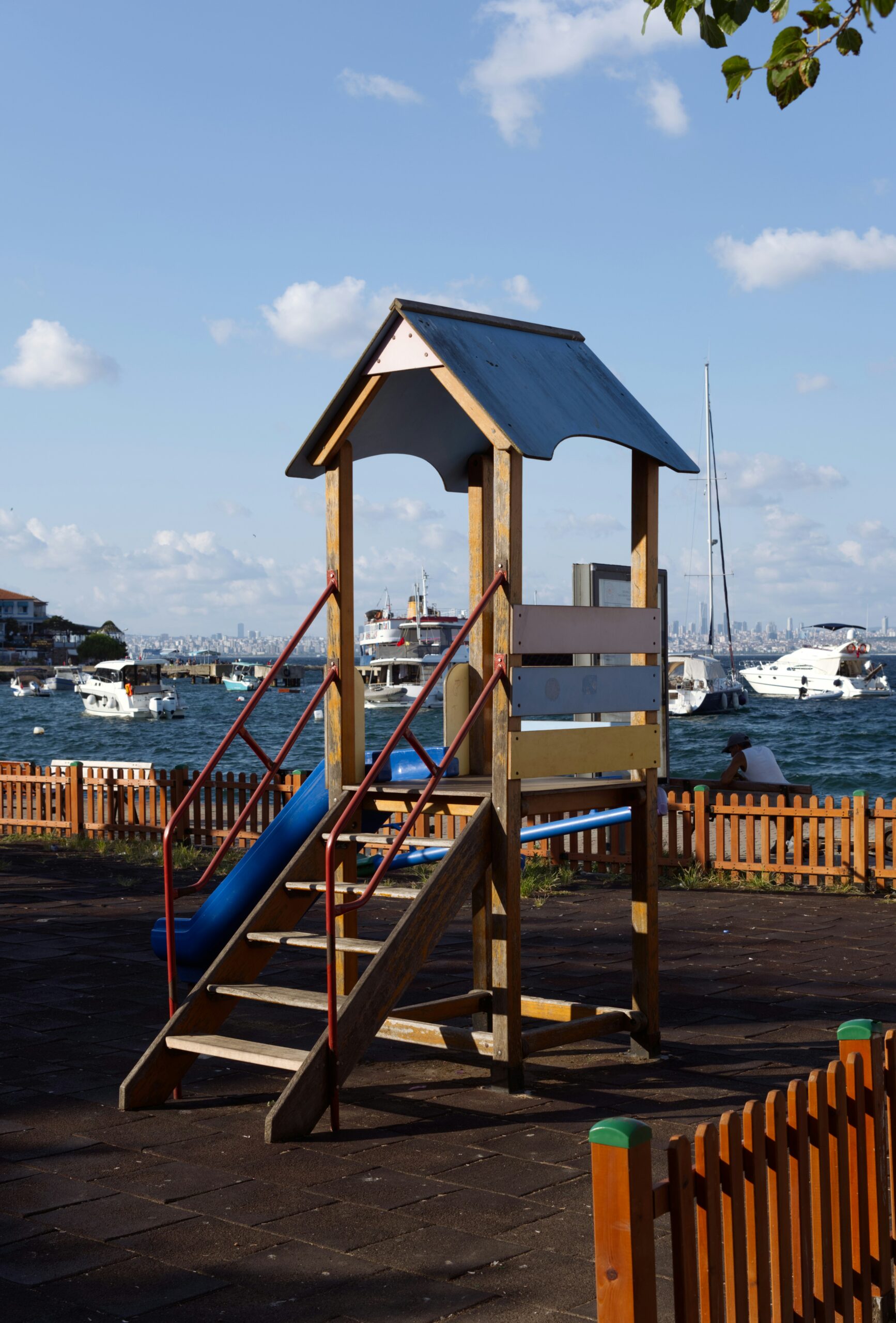 A wooden play structure with a blue roof